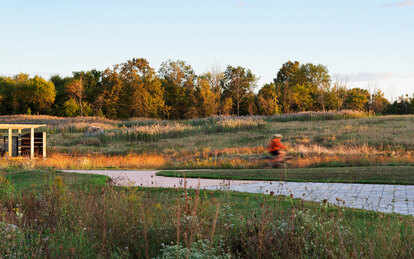 Photo of bicyclist riding the trail through the park's restored native landscape